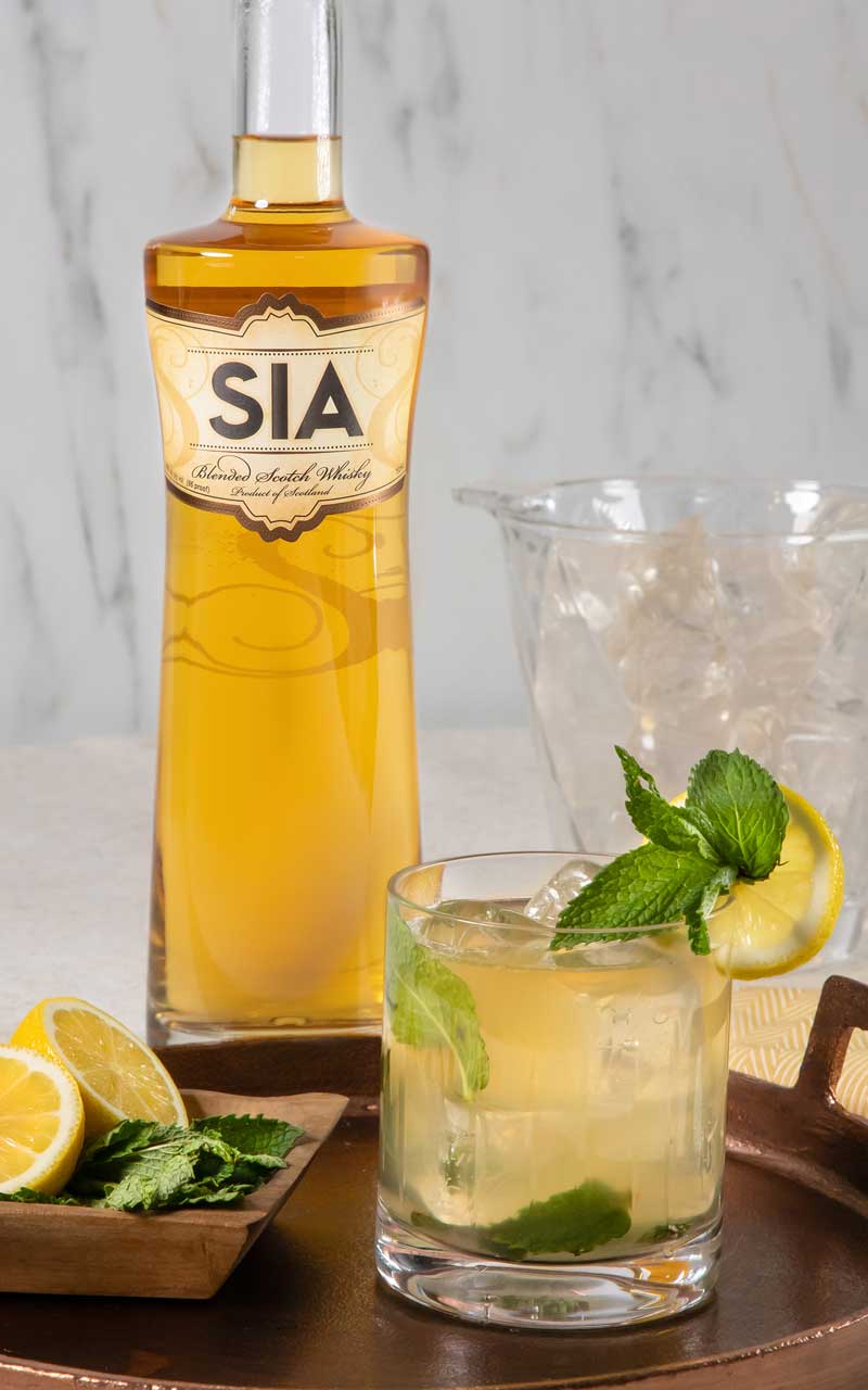 A bottle of SIA Blended Scotch Wisky behind a SIA Smash cocktail